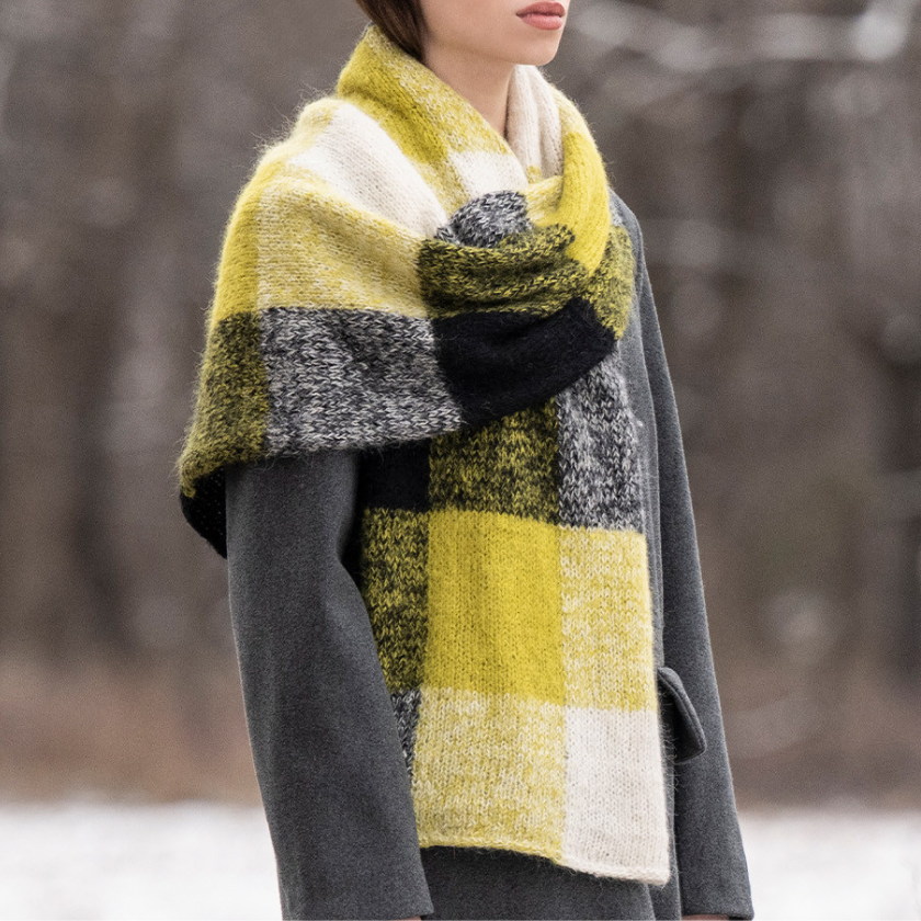 Model wearing a the Amsterdam Scarf and gray coat in a snowy landscape
