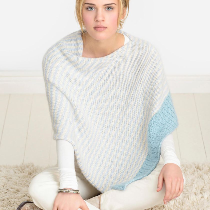 Woman sitting cross legged on a fuzzy carpet in the Winter Shoreline striped Bianca Wrap