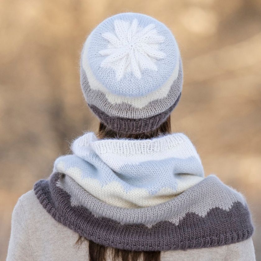 Model showing the back of the Camino Cowl and hat bundle against a blurred natural background