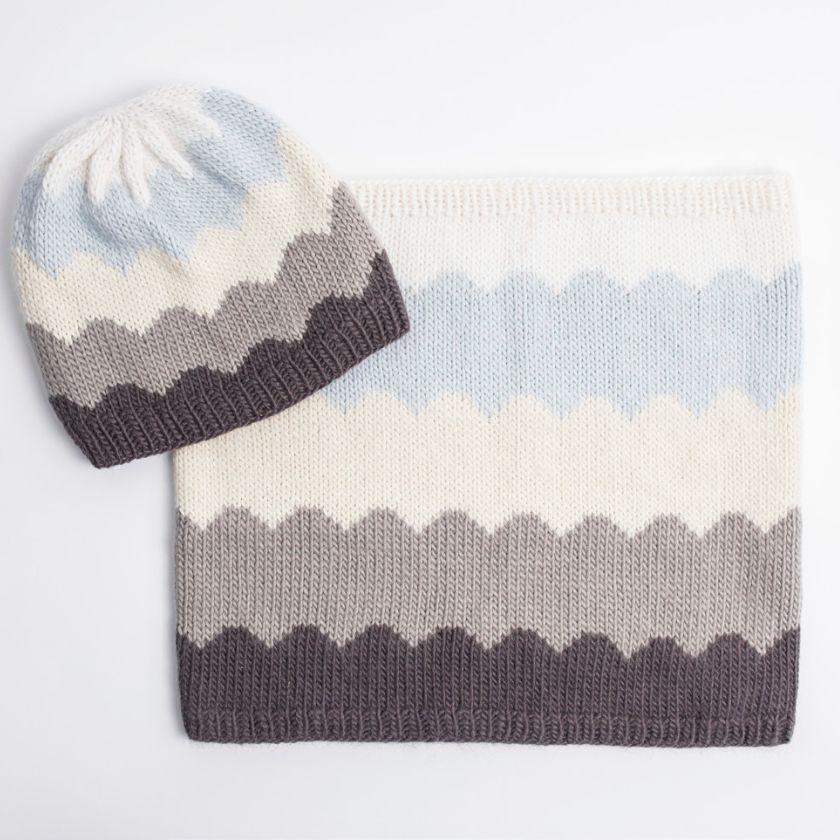 Knitted Camino cowl and hat set with striped pattern on a light gray background