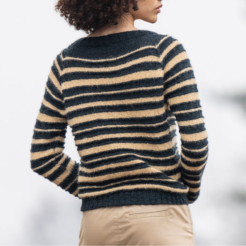 Back view of the Saturnalia Pullover with varying widths of dark and light horizontal stripes on a model.
