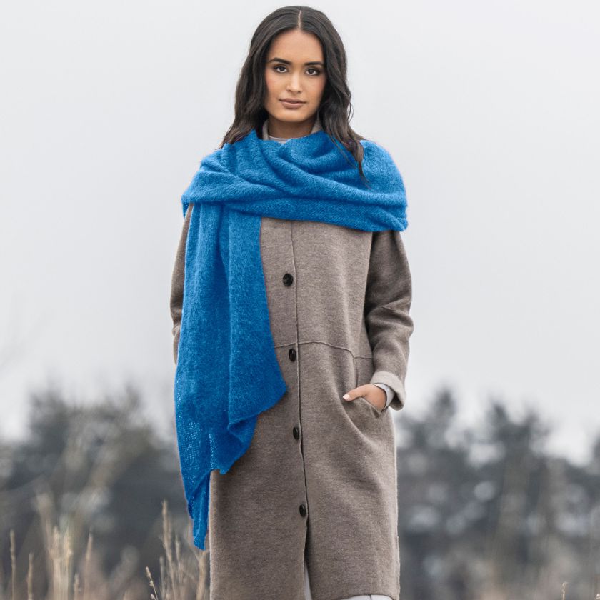 Model wears a scarf in Aster yarn from the Dizzy Knitter