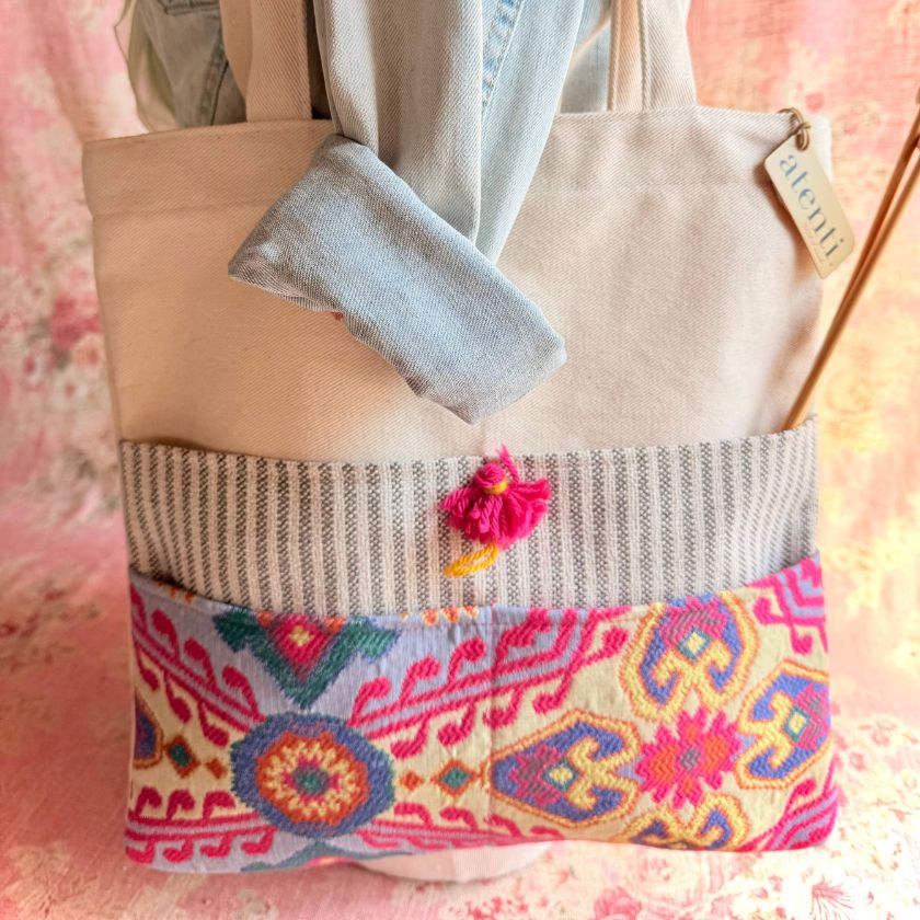 Atenti knitting bag with colorful pattern and textured pocket on a pink floral background