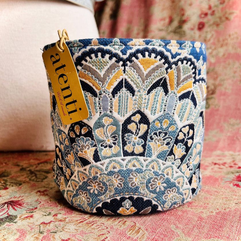 A fabric storage container with a floral mandala-like pattern in blue and gold colors by Atenti Bags