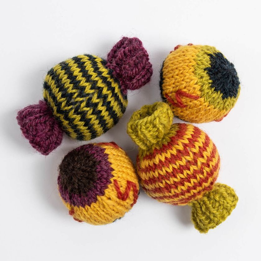 Colorful knitted toys of candy and eyeballs on a white background