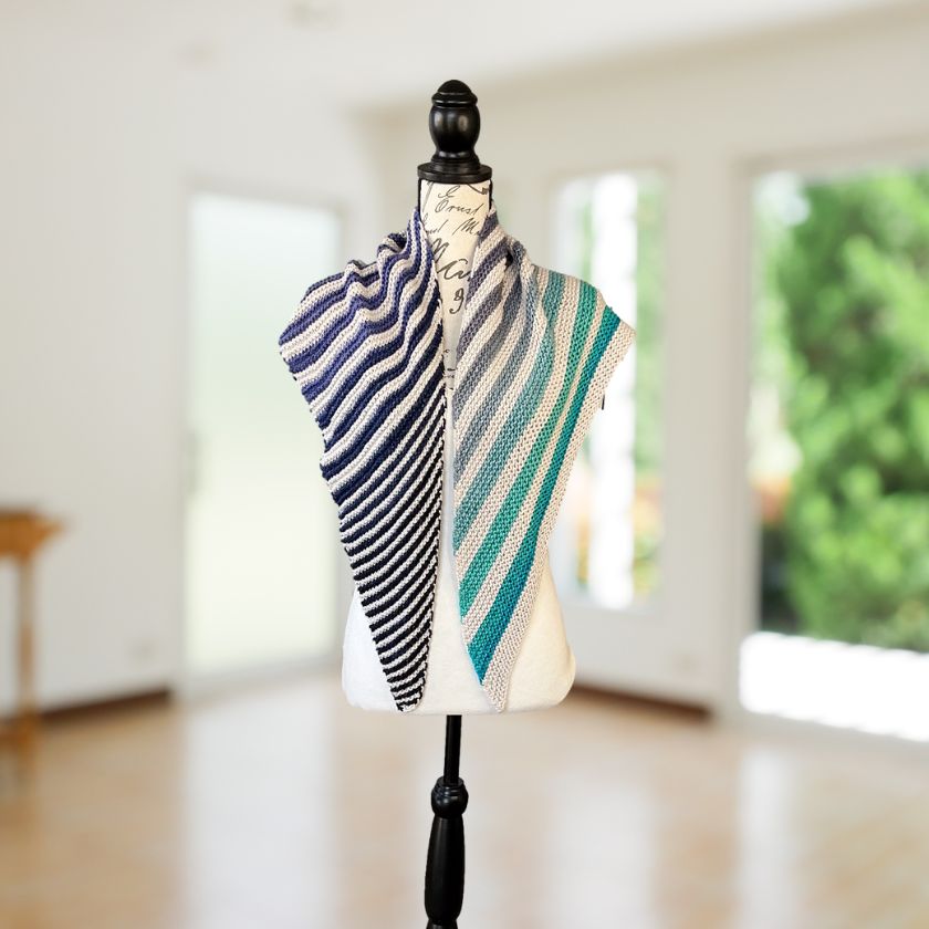 Cumulus cotton yarn knitted into a shawl in greys and blues on a mannequin bust