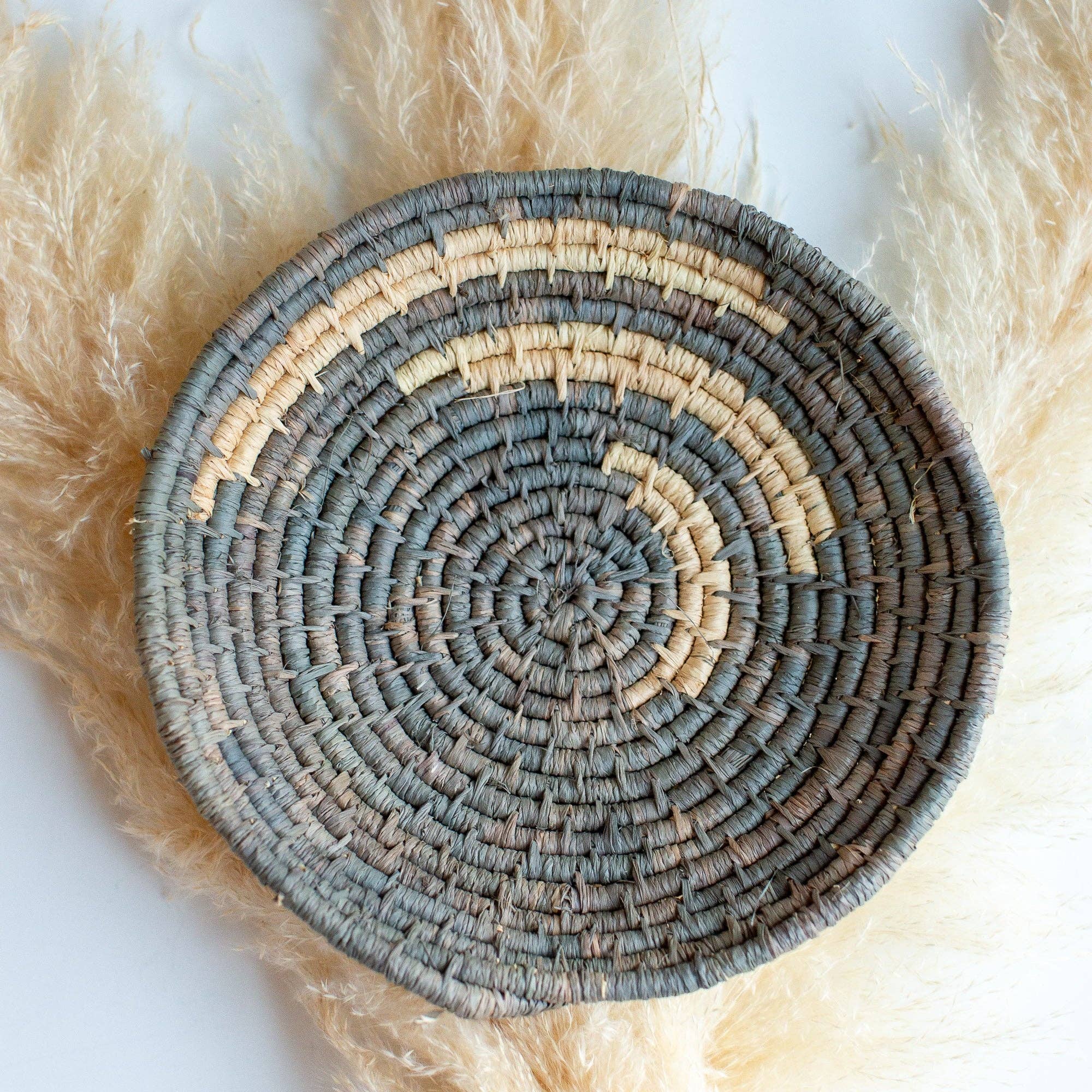 Round woven Autumn Basket with concentric circle pattern on a white background