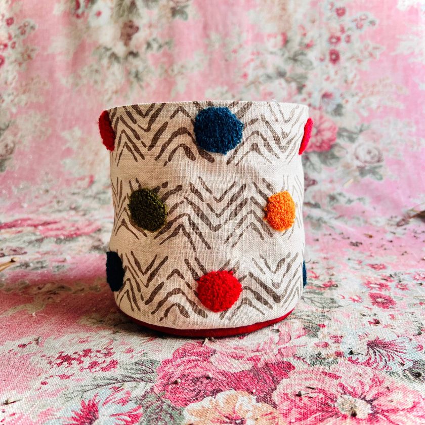 The Dottie Tiny Tucker fabric storage container with a floral mandala-like pattern in blue and gold colors from Atenti Bags