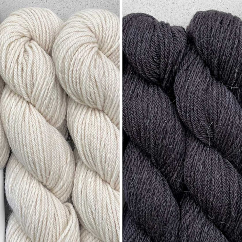 Skeins of yarn for the Milano Sweater knitting pattern in Ecru and Black