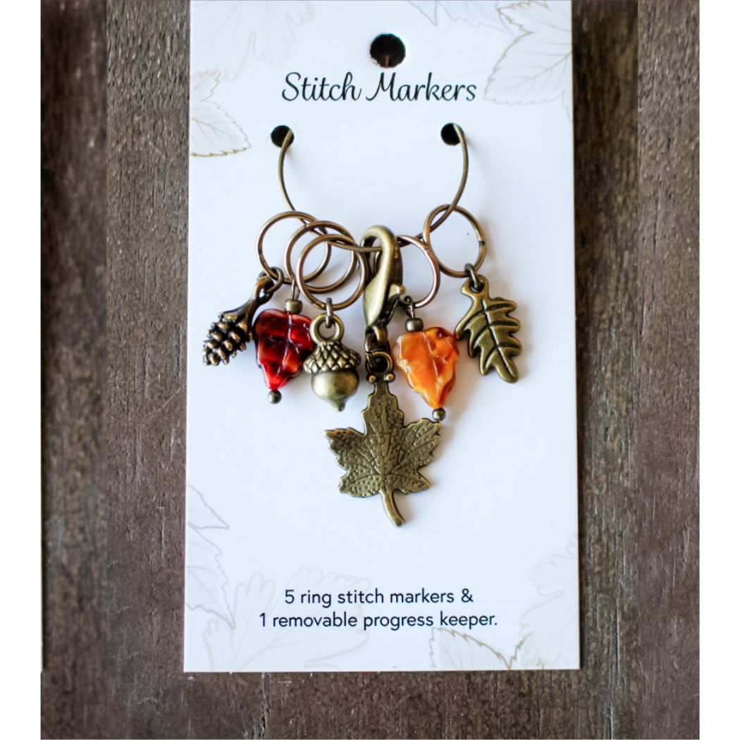 Set of stitch markers with leaf and acorn charms on a white card labeled 'Stitch Markers'.