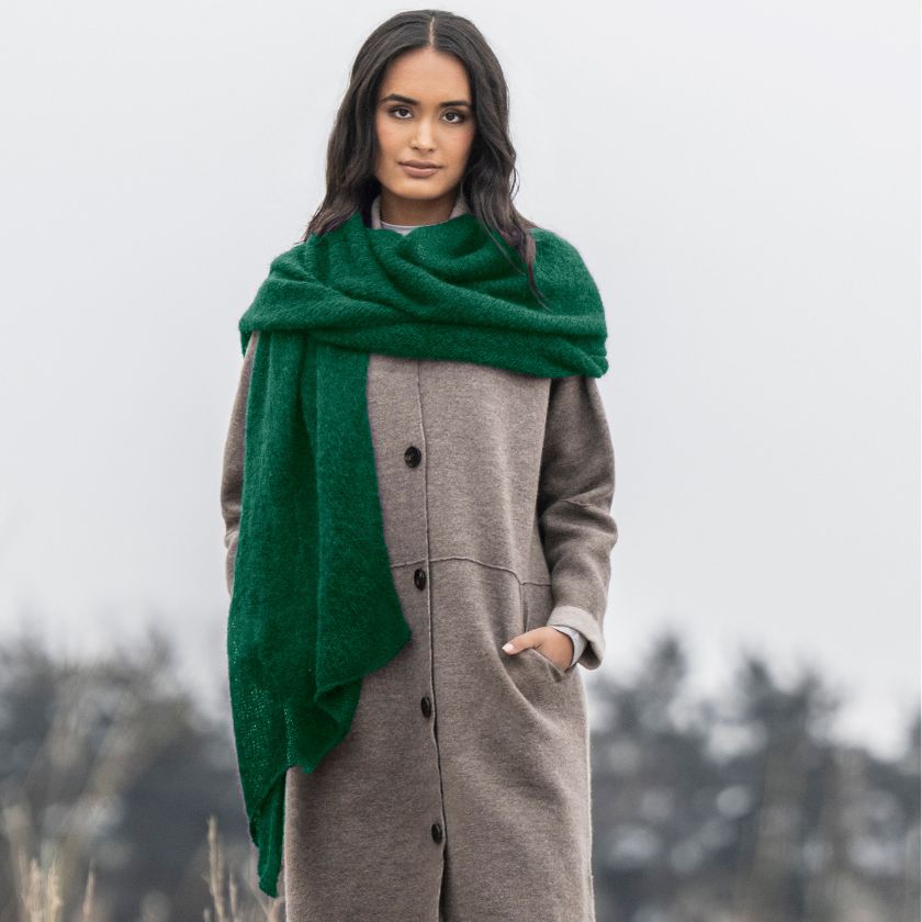 Model wears a scarf in Hummingbird yarn from the Dizzy Knitter