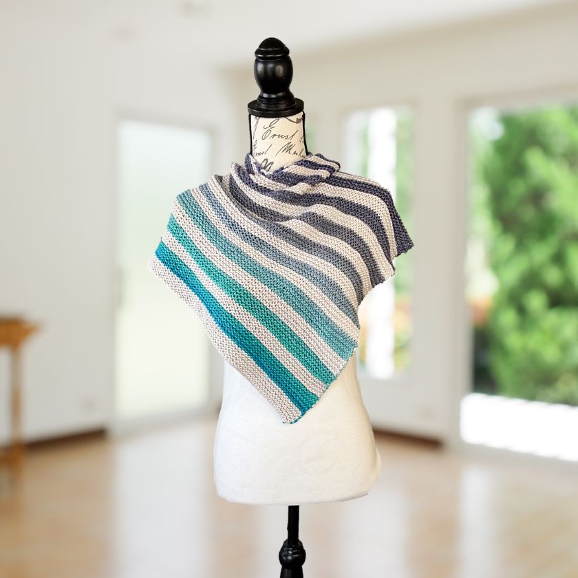Cumulus cotton yarn from Juniper Moon Farms knitted into a shawl in greys and blues on a mannequin bust