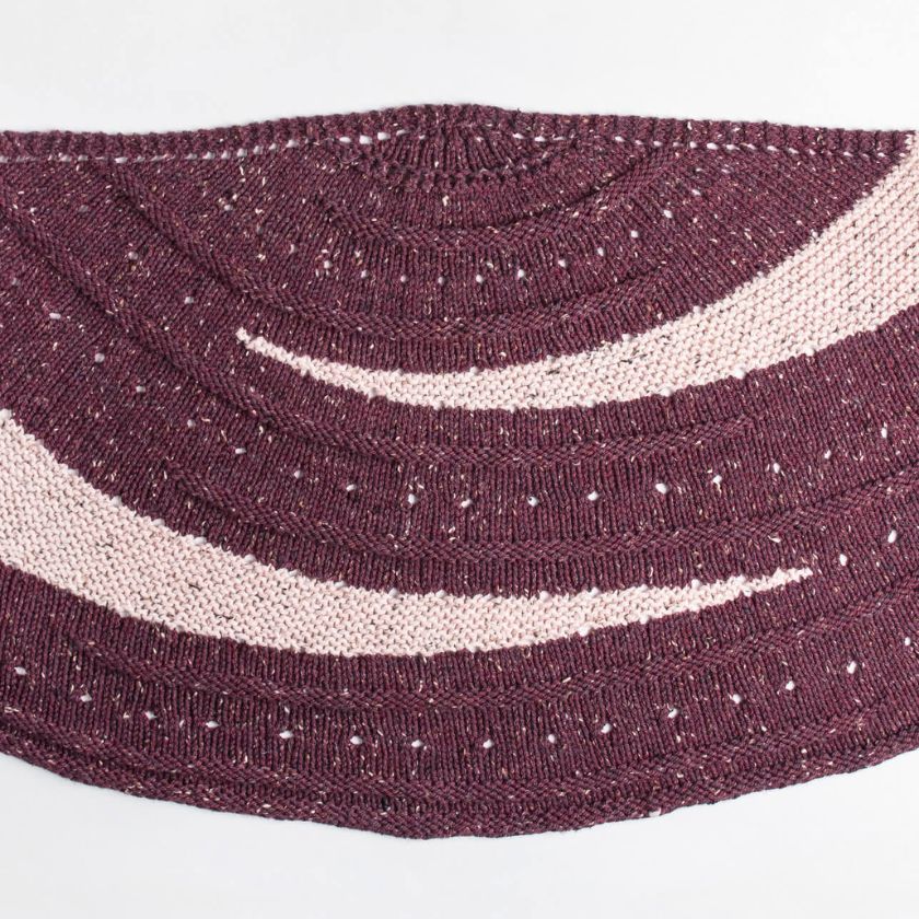 Flat lay of the Kelso Wrap knit wrap showing semi-circular shape, textured ridges, and contrast stripes in tweed yarn.