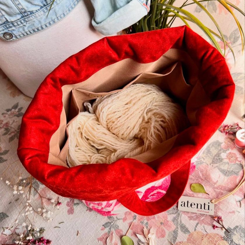 The Lalique Hope knitting bag by Atenti Bags filled with yarn next to a denim jacket