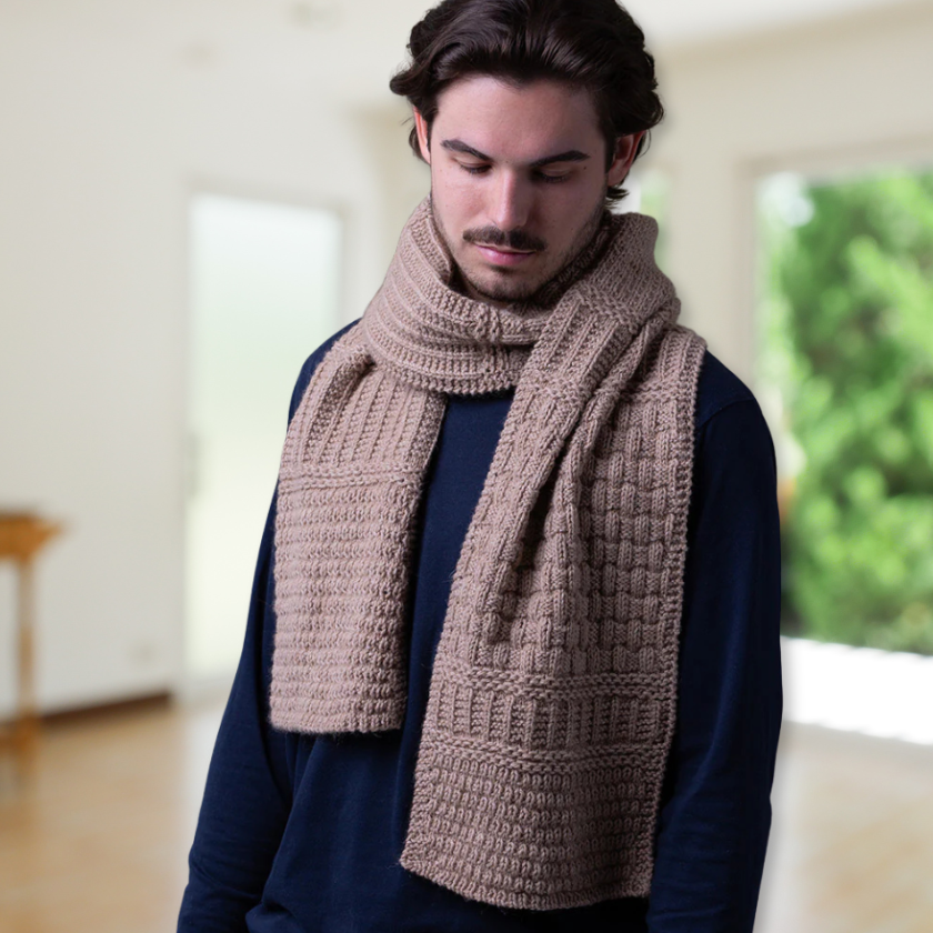 Man wearing a long brown knitted Pascuali Mix it Up scarf indoors