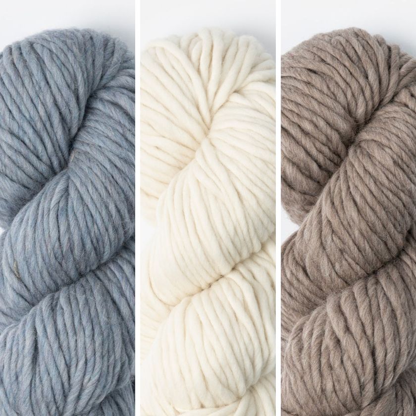 Three skeins of yarn in Morning Frost, Highland Fleece, and Gravel Road on a white background