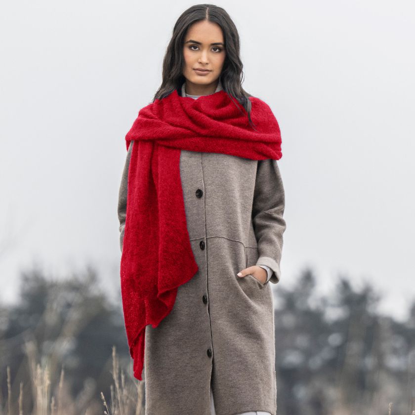Model wears a scarf in Sumac yarn from the Dizzy Knitter