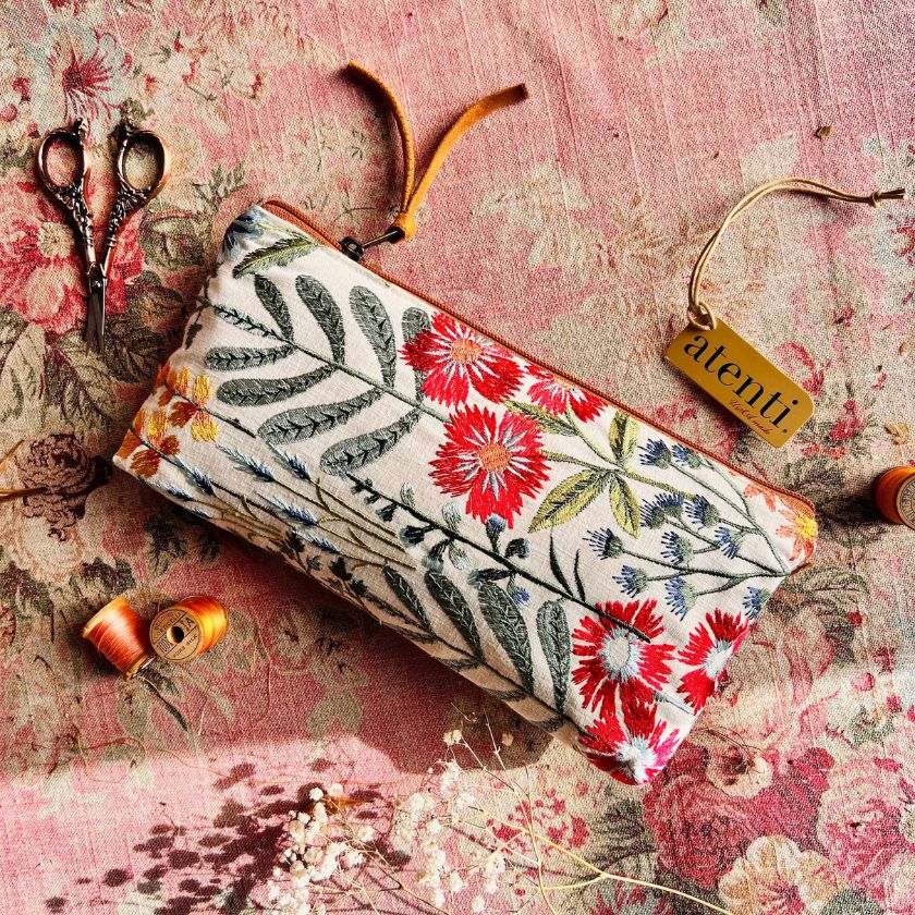 The Wildflower Pouch from Atenti Bags on a floral fabric amongst sewing gear