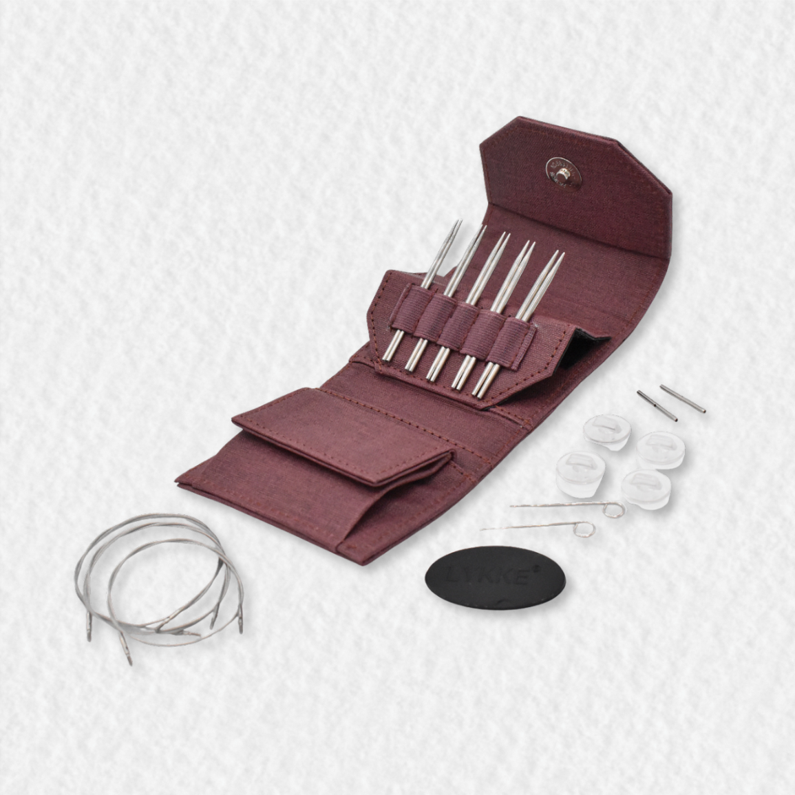Set of Lykke Flight knitting needles in a maroon case on a white background