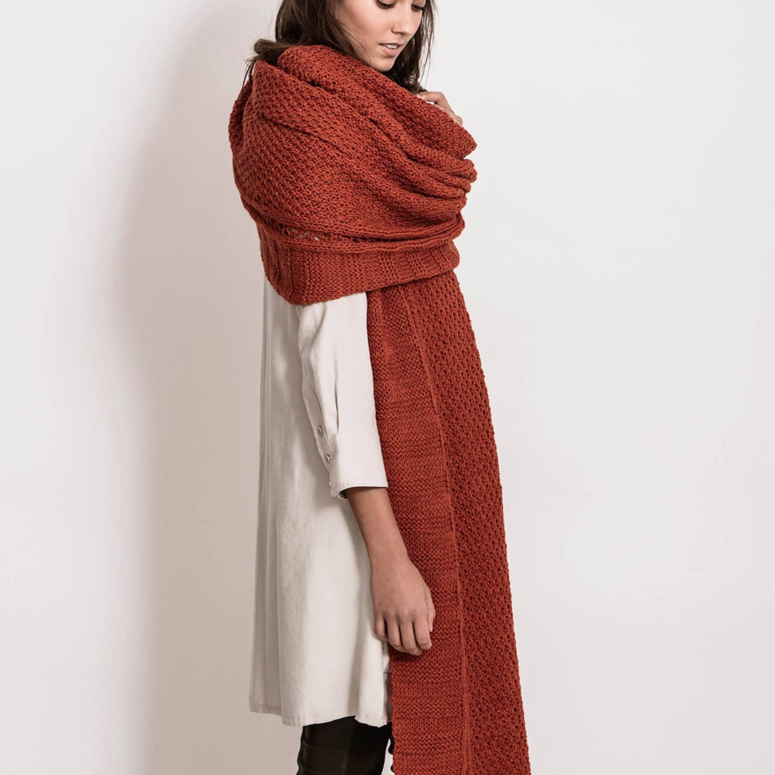 Side view of the Endless Wrap knit scarf draped around the shoulders, showing layered texture and elegant wrap styling.