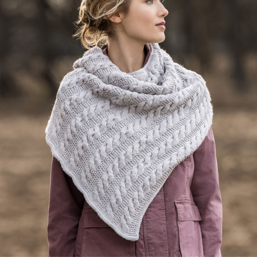 Model wearing a textured Livonia shawl on a plain background