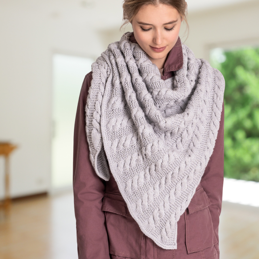 Model wearing a textured Livonia shawl on a plain background