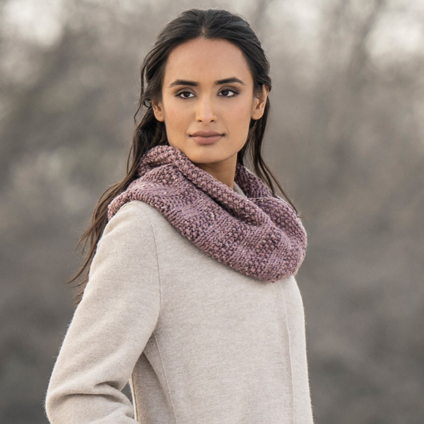 Angled view of the Lulu Cowl knit cowl worn loosely around the neck, showcasing its squishy texture and classic shape.