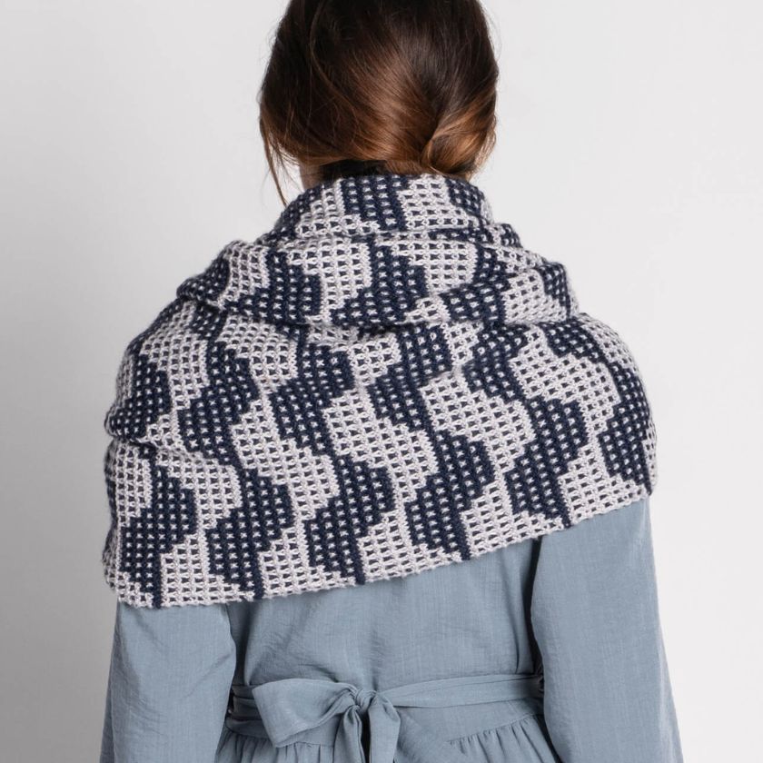 Model showing the back of the patterned knitted Market Street wrap against a gray background