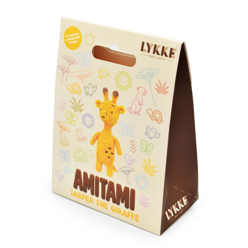 Packaging of an Amitami giraffe knitting kit with 'LYKKE' branding on a white background