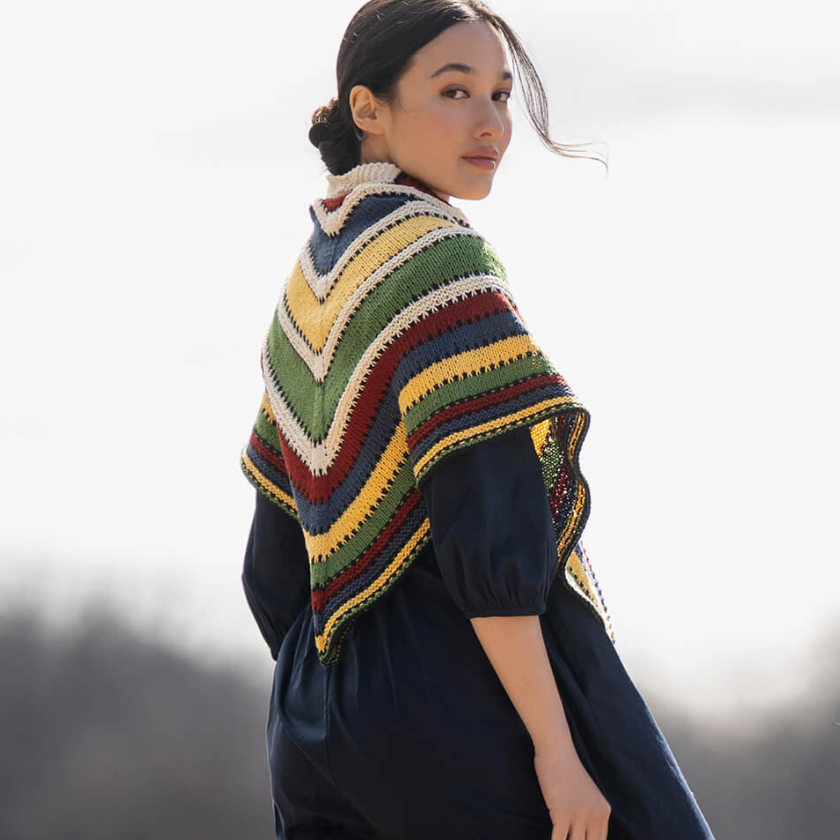 Model wearing the Camp Ivanhoe Shawl Kit by Blue Sky Fibers, featuring bold stripes in Organic Cotton Sport yarn.