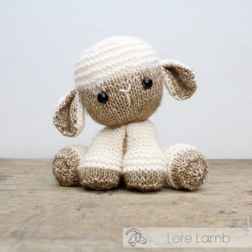 Completed Lore Lamb knitting kit by Amigurumi on a wooden surface with a light gray background