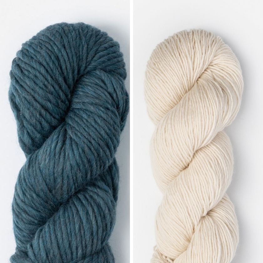 Two skeins of yarn for the Spangle Cowl, one Loon Lake blue and one highland fleece white, on a white background.