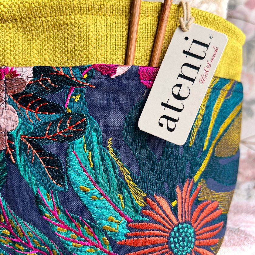 Colorful embroidered fabric knitting project bag with floral patterns and 'atenti' brand tag